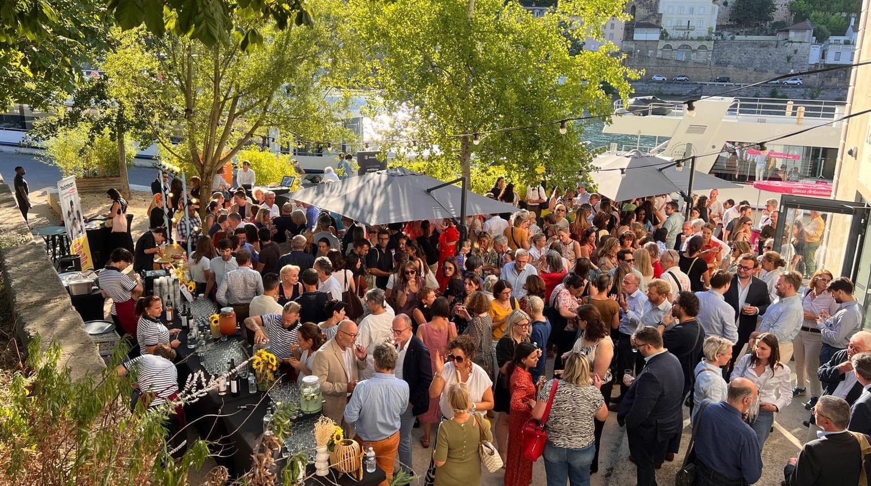 Food court événementiel en extérieur : une foule de convives circule entre les stands.