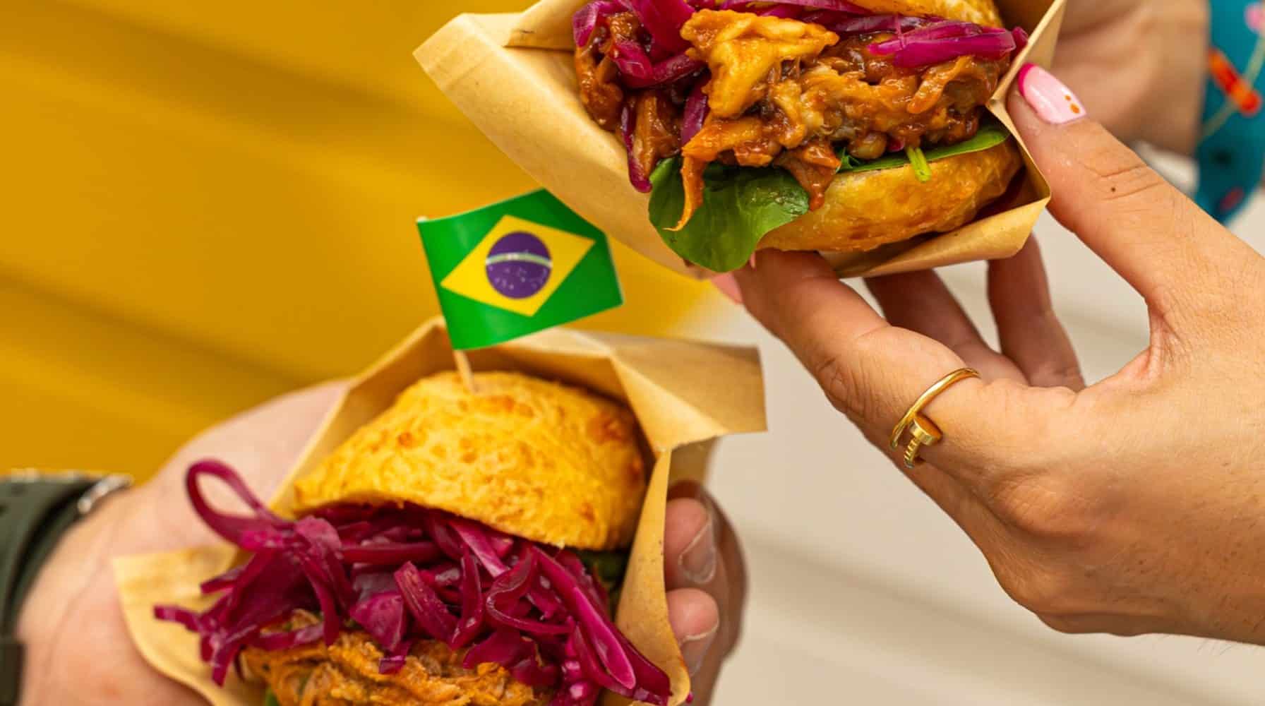 Deux sandwichs de street food brésilienne tenus en main lors d'un événement à Lyon.